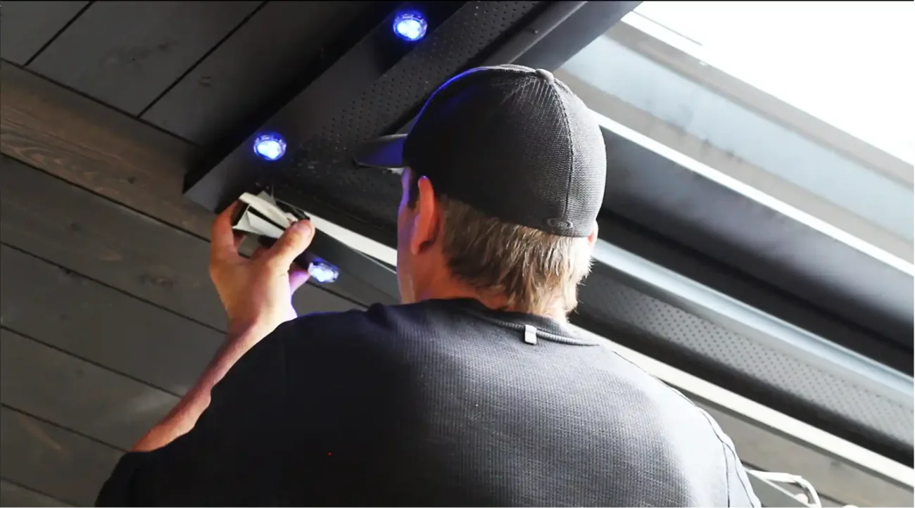 Architectural Ambiance technician installing recessed LED modules into a color-matched soffit track