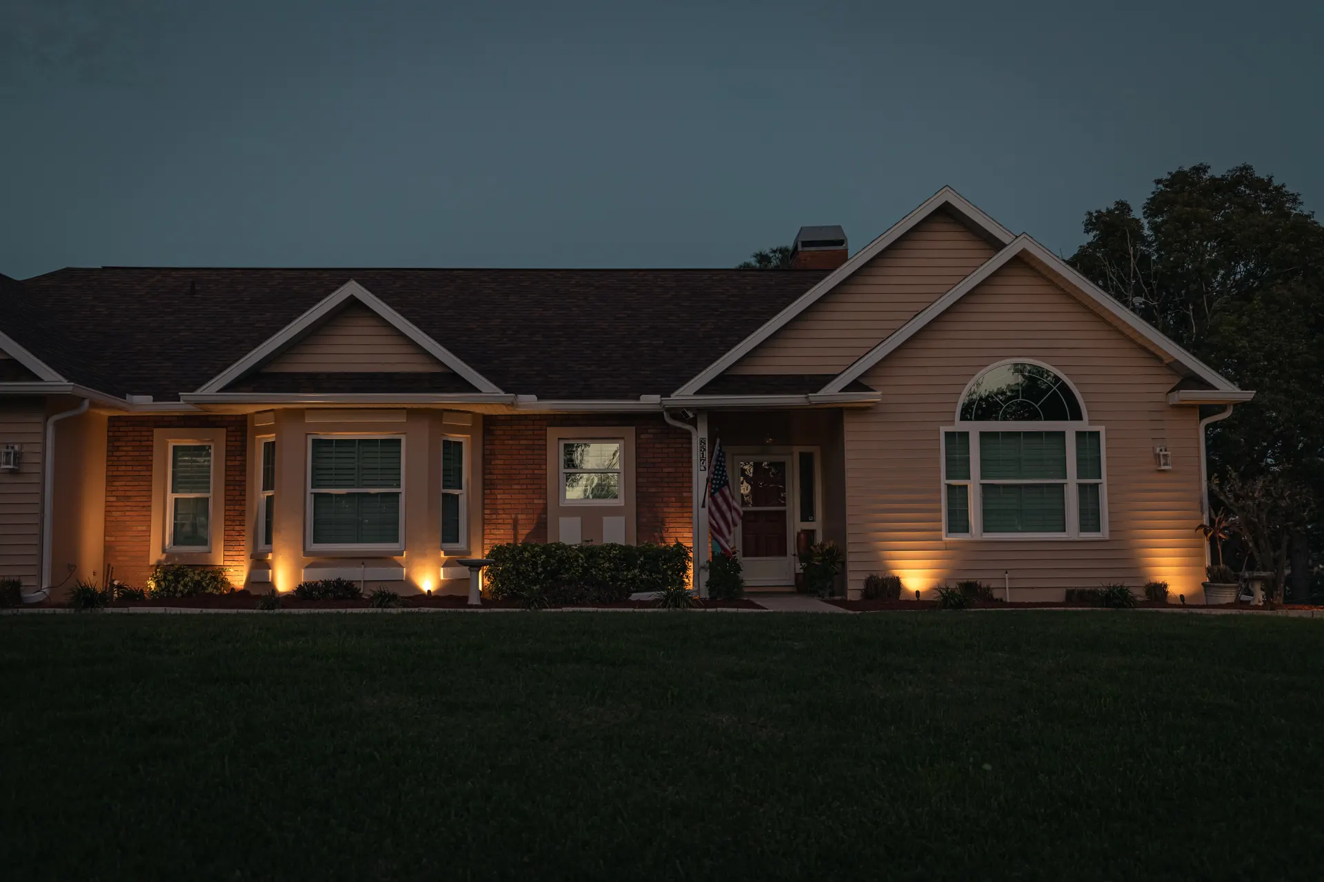 Home at dusk with balanced warm uplights, deep blue sky, well exposed