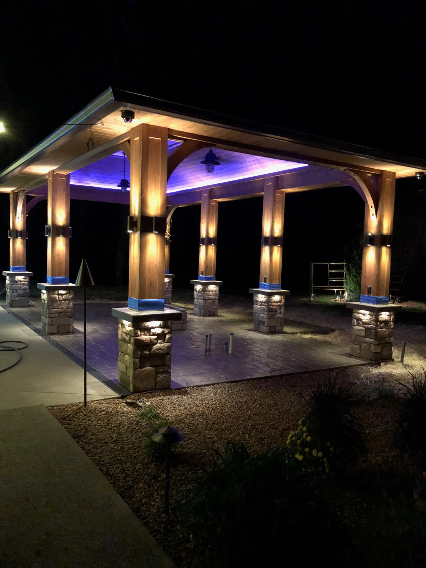 Night pavilion with warm column uplighting and blue accent ceiling glow