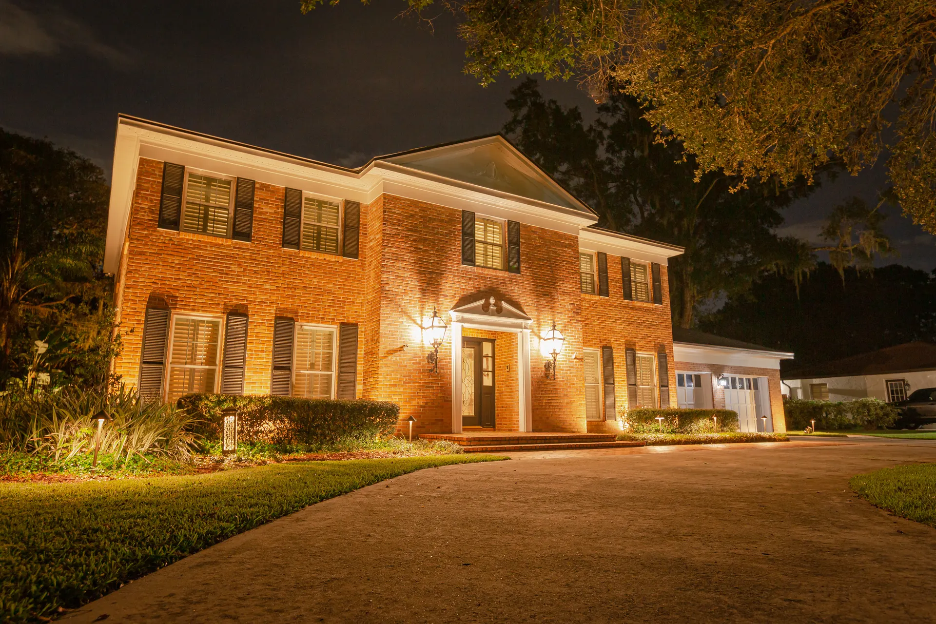 Classic warm-white facade uplighting on brick colonial, elegant night