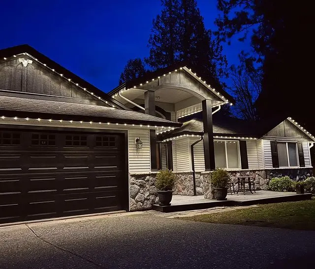 Craftsman home at dusk with warm white permanent lighting tracing the rooflines and porch