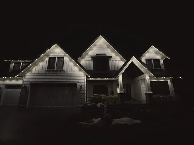 Three-gable home tastefully outlined in warm white permanent lighting at night